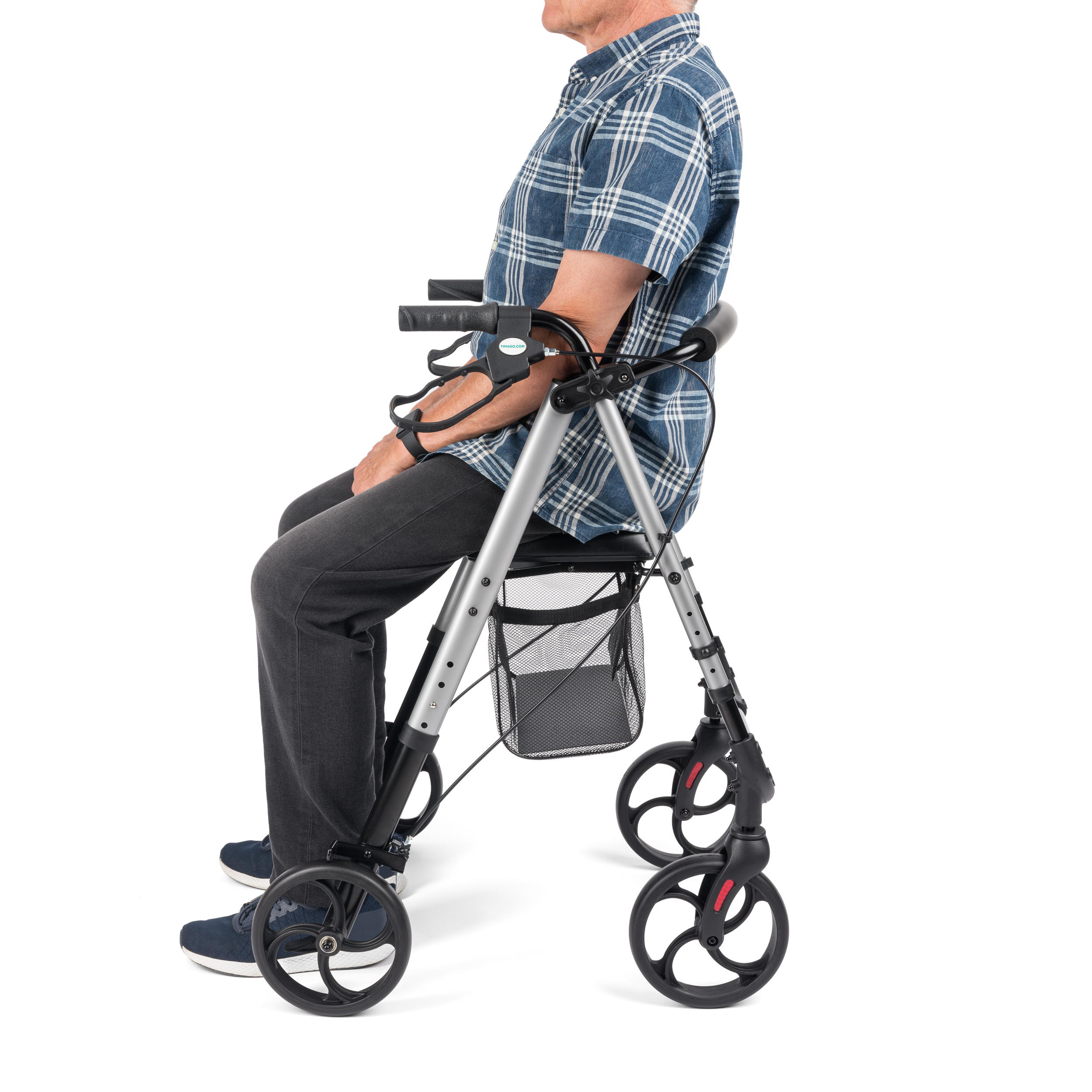 rolator_alina_3 - fizio trgovina person sitting in a blue plaid shirt using a knee walker with forearm crutches attached on each side.