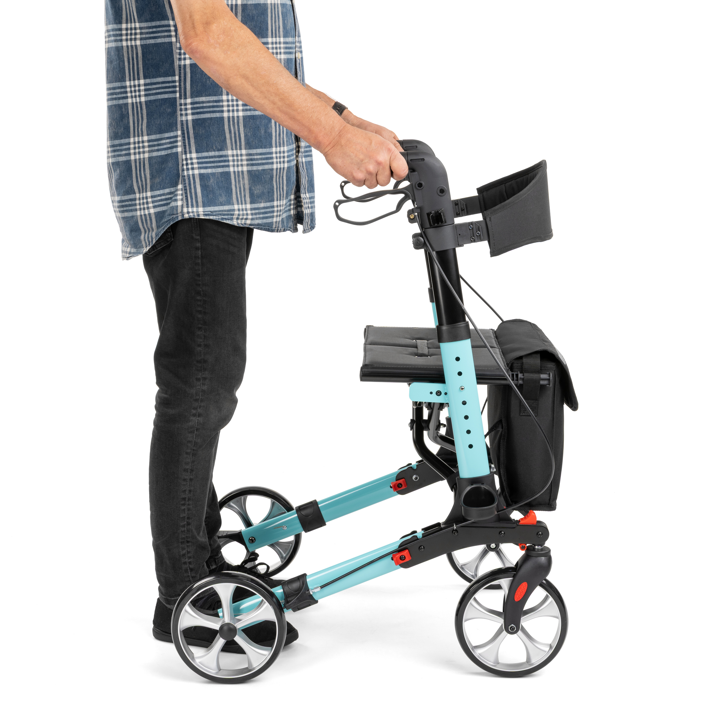 rolator_yola_3 - fizio trgovina person in a blue plaid shirt standing beside a turquoise foldable mobility scooter, gripping the handlebar.
