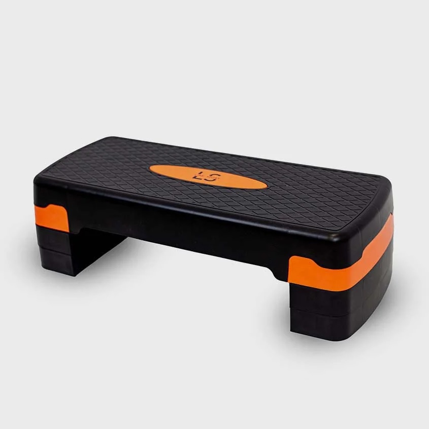 steper_za_aerobiko_5 - fizio trgovina black and orange workout step platform with textured top and orange accents on the sides, used for step exercises.