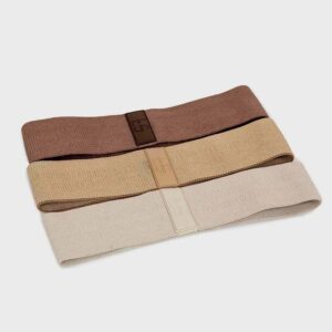Set of three fabric fitness resistance bands in brown, tan, and beige with branded metal clasps.]??