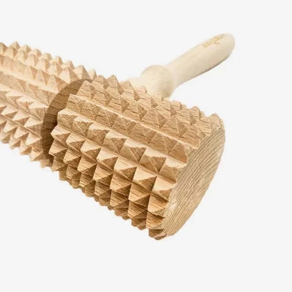 masazni_valjcek_12 - fizio trgovina wooden massage roller with knobby geometric studs and a light handle, used for muscle relief improvisation tool.