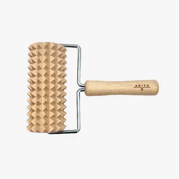 masazni_valjcek_4 - fizio trgovina textured wooden rolling pin with pyramid-pattern roller and a light wood handle labeled akito